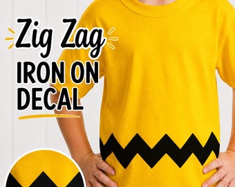 May include: A bright yellow t-shirt featuring a horizontal black zig-zag pattern across the midsection. The text "Zig Zag IRON ON DECAL" is printed in black and white. A circular inset shows a close-up of the black zig-zag design on yellow fabric.