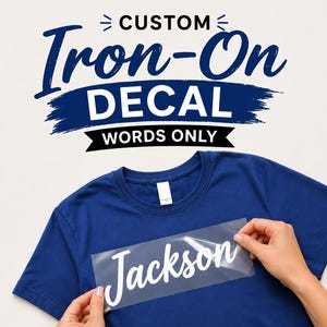 Peut inclure: Un t-shirt bleu foncé avec une feuille de transfert transparente portant le texte en écriture blanche Jackson. Au-dessus du t-shirt, le texte indique CUSTOM Iron-On DECAL WORDS ONLY en bleu foncé et noir, avec des accents de pinceau.