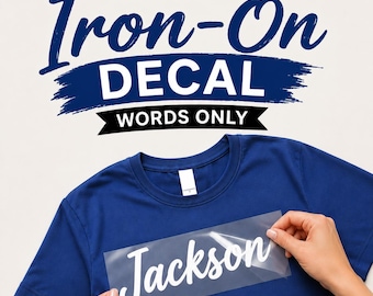 May include: A solid blue t-shirt with a clear transfer sheet featuring the white script text Jackson. Above the shirt, bold dark blue and black text reads CUSTOM Iron-On DECAL WORDS ONLY, indicating a personalized heat transfer product.
