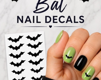 May include: A sheet of black bat nail decals featuring two columns of small bat silhouettes. The text "Bat NAIL DECALS" appears at the top. The decals are shown applied to fingernails painted in alternating light green and black polish.