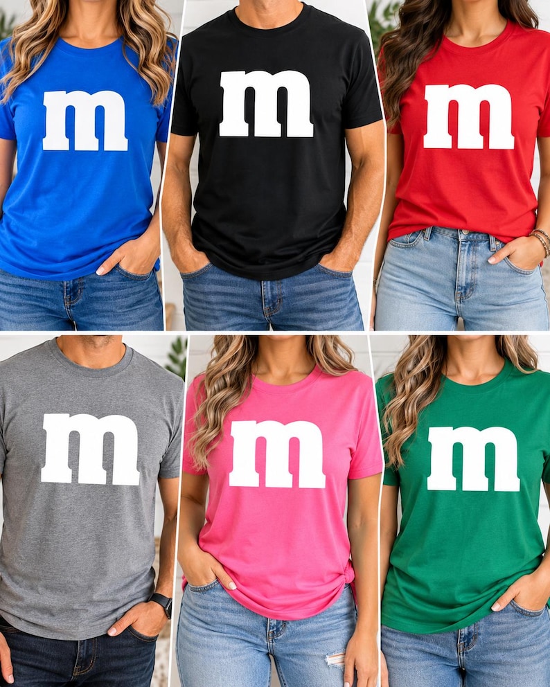 May include: A collection of six short-sleeved crew neck t-shirts in blue, black, red, gray, pink, and green. Each shirt features a large, white, lowercase letter m printed in the center of the chest, mimicking the iconic candy logo design.