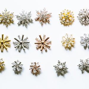 Puede incluir: Surtido de dijes en forma de copo de nieve con adornos de cristal en acabados dorado, plateado y oro rosa. Los dijes son perfectos para la elaboración de joyas, el scrapbooking y otros proyectos de manualidades.