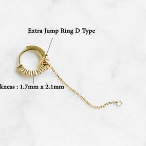 Peut inclure: Anneau de saut en or avec une cha&icirc;ne attach&eacute;e. L'anneau mesure 1,7 mm x 2,1 mm d'&eacute;paisseur. L'anneau est &eacute;tiquet&eacute; "Extra Jump Ring D Type".