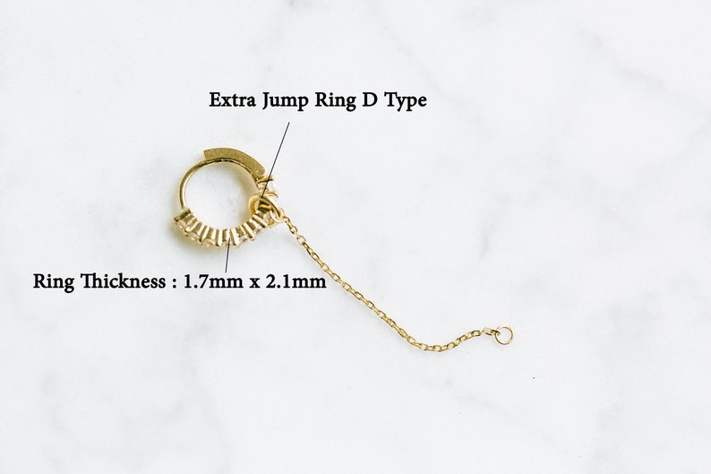 Peut inclure: Anneau de saut en or avec une cha&icirc;ne attach&eacute;e. L'anneau mesure 1,7 mm x 2,1 mm d'&eacute;paisseur. L'anneau est &eacute;tiquet&eacute; "Extra Jump Ring D Type".