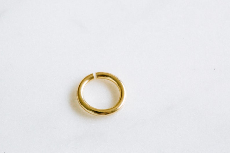 Peut inclure: Un anneau de jonction en m&eacute;tal dor&eacute;, un type de composant de bijouterie utilis&eacute; pour relier les composants de bijoux.