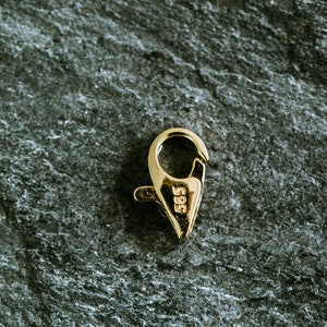 May include: Gold-toned metal clasp with a spring-loaded closure. The clasp is marked with the number "585".