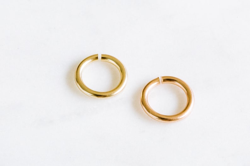 Peut inclure: Deux anneaux de saut en or, l'un en or brillant et l'autre en or rose. Les anneaux sont ouverts et pr&ecirc;ts &agrave; &ecirc;tre utilis&eacute;s pour la fabrication de bijoux.