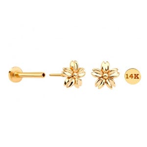 May include: Gold-colored jewelry set featuring a flower design. The set includes a flower-shaped stud earring, a flower-shaped earring, a flat-back earring, and a small round piece with the text "14K".