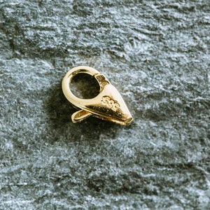 May include: Gold-toned metal clasp with a spring-loaded closure. The clasp is marked with "925" on the side.