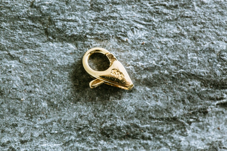 May include: Gold-toned metal clasp with a spring-loaded closure. The clasp is marked with "925" on the side.