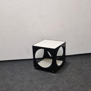 May include: A black side table with a white top and two circular cutouts. The table has a modern design and is made of a durable material.