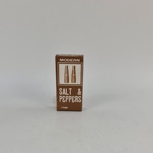 Könnte beinhalten: Eine braune Schachtel mit dem Text "MODERN HAND WOOD SALT & PEPPERS 1 PAIR" darauf. Die Schachtel enthält zwei kleine Salz- und Pfefferstreuer.
