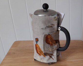 An attractive cotton cafetiere cover / coffee pot cover in a pheasant design.