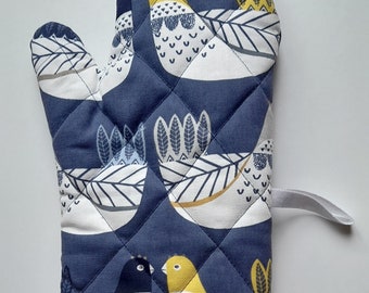 A stylish quilted padded oven glove / oven mitt / pot holder in organic cotton in a cluckcluck design  on navy background.