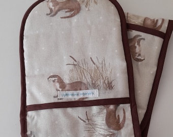 Otter design Double oven gloves  in thick padded cotton trimmed in brown binding.