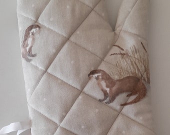 Oven glove / oven mitt / pot holder in a design of otters in thick cotton fabric, quilted, lined and padded.