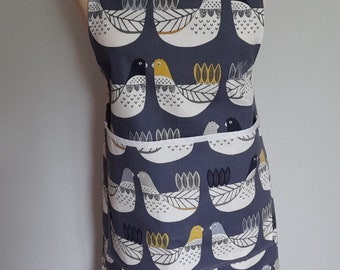 Adult apron in CluckCluck bird design ,Navy blue and white with yellow splashes. Patch pocket trimmed in white.