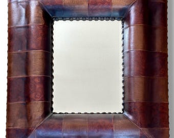Vintage mid century leather cushion framed mirror with brass stud edging.
