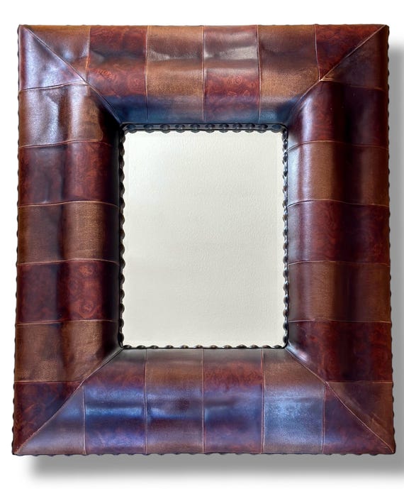 Vintage mid century leather cushion framed mirror with brass stud edging.