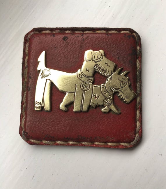 Ric et Rac brass and red leather badges Pol Rab French cartoon dogs circa 1920's