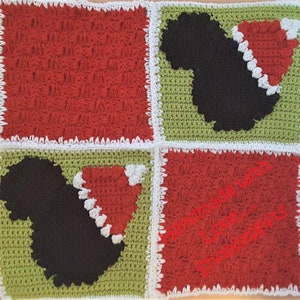 Peut inclure: Une couverture carrée en crochet de couleur rouge et verte. La couverture présente une silhouette noire d'une personne portant un bonnet de Père Noël dans chaque coin. Le texte "Handmade with Love..." est visible dans le coin inférieur droit.
