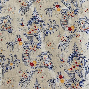 May include: Cream-colored fabric with a repeating pattern of blue pagodas, floral elements, and red and yellow accents. The design has an Asian-inspired aesthetic, suitable for home decor or apparel.