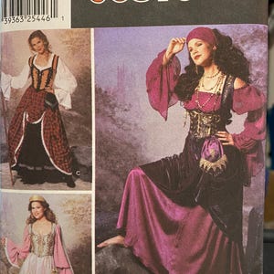 May include: A Simplicity Costumes pattern featuring three medieval-style costume designs. The costumes include long dresses with detailed bodices, sleeves, and accessories. The pattern includes sizes 14, 16, 18, and 20.