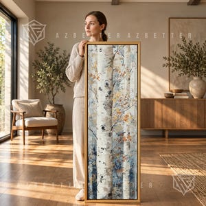 May include: A tall, rectangular framed wall art piece featuring a detailed painting of white birch tree trunks with textured bark, interspersed with delicate branches and autumn-toned leaves in shades of gold, orange, and muted blue.