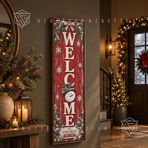May include: A vertical rectangular wooden sign with a red textured background featuring the word WELCOME in large white letters. A snowman illustration replaces the letter O, and the text THE EDWARDS SINCE 2020 appears at the bottom.
