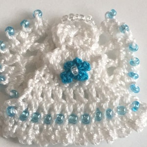 May include: White crocheted angel ornament with a blue flower and blue bead trim.