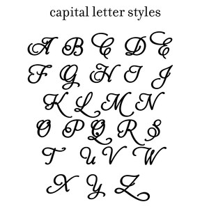 May include: A black and white image of the alphabet in a cursive font style. The letters are written in a flowing, elegant script.