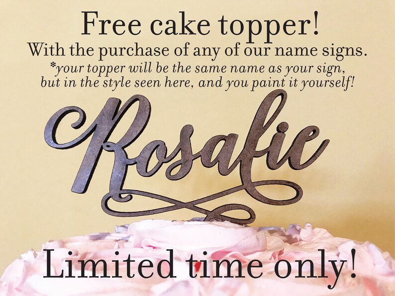 May include: A wooden cake topper with the name "Rosalie" written in a cursive script. The topper is on a pink and white frosted cake. The text "Free cake topper! With the purchase of any of our name signs. *your topper will be the same name as your sign, but in the style seen here, and you paint it yourself! Limited time only!" is written on a yellow background.