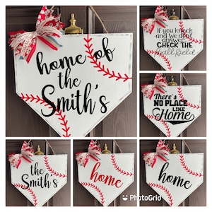May include: Baseball-themed home decor sign in the shape of a home plate. The white sign features red stitching, a decorative bow, and the text "home of the Smith's". Other signs say "If you knock and we don't answer... CHECK THE ball field" and "There's NO PLACE LIKE Home".