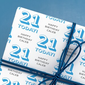 Puede incluir: Papel de regalo blanco con un patr&oacute;n azul y blanco. El patr&oacute;n presenta el n&uacute;mero 21 repetido en todo el papel. El texto "Happy Birthday Caleb" y "Today!" tambi&eacute;n se repite en todo el papel.