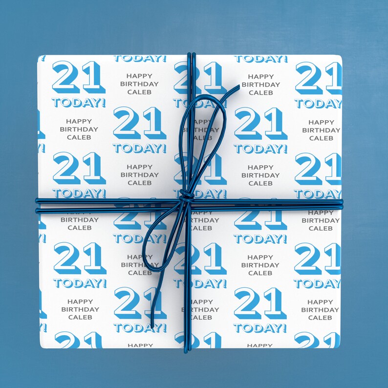Puede incluir: Papel de regalo blanco con un patr&oacute;n azul y blanco. El patr&oacute;n presenta el n&uacute;mero 21 y el texto "&iexcl;Hoy! Feliz cumplea&ntilde;os Caleb".