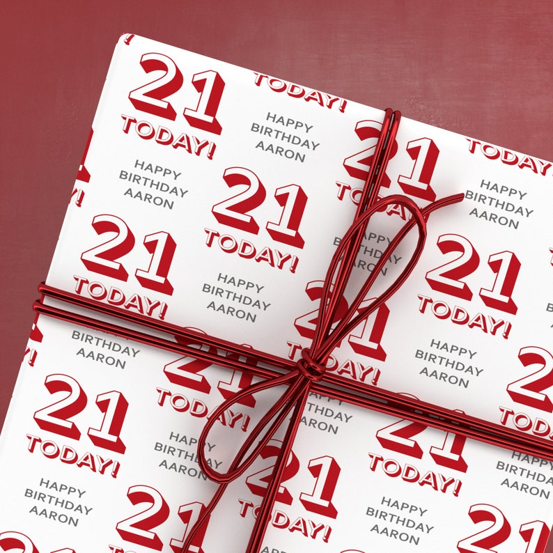 Puede incluir: Papel de regalo blanco con una cinta roja. El papel est&aacute; impreso con el n&uacute;mero 21 y el texto "&iexcl;Hoy! Feliz cumplea&ntilde;os Aaron".