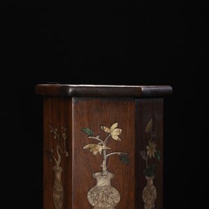 May include: A hexagonal wooden box with intricate floral designs inlaid with mother of pearl and other materials. The box has a dark brown finish and is decorated with three different floral motifs.