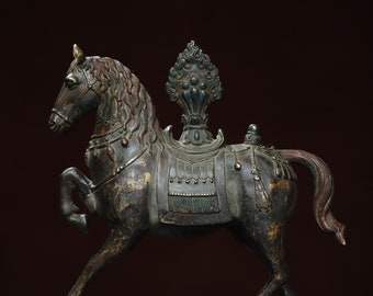 Puede incluir: Una estatua de caballo de bronce con una silla de montar decorativa y un diseño floral en la espalda. El caballo está de pie sobre una base de madera.