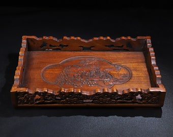 May include: A rectangular wooden tray with a carved design of a landscape scene. The tray has a scalloped edge and is made of dark brown wood.