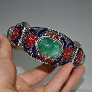 May include: A silver bracelet with a green jade stone and red and blue enamel flowers.