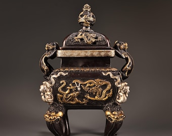 Op de afbeelding: Omsiers bronzen wierookbrander met ingewikkelde draken- en leeuwendetails. Het donkerbruine vat heeft gouden accenten, waaronder draken op het lichaam en deksel, en leeuwenkoppen op de poten. De handvatten zijn gevormd als mythische wezens.