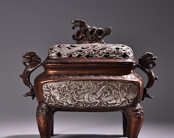 Op de afbeelding: Een bronzen wierookbrander met een drakenontwerp. De brander heeft een deksel met een drakenknop en drie poten. Het lichaam van de brander is versierd met draken en wolken.
