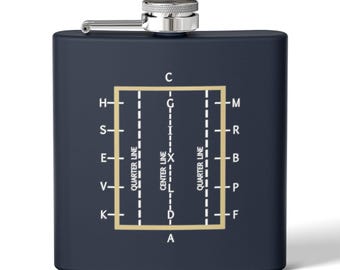 Peut inclure: Une flasque bleu marine avec un bouchon et une charnière argentés. La flasque présente un rectangle doré avec un diagramme de lignes et de lettres, dont "Quarter Line" et "Center Line".