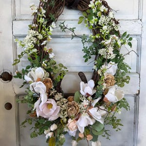 Equestrian grapevine wreath magnolias leather reins horsehoe.