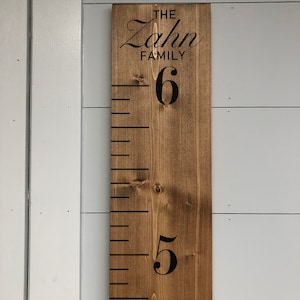 May include: A wooden growth chart with black markings and numbers. The chart is stained brown and has the text "The Zahn Family" at the top.