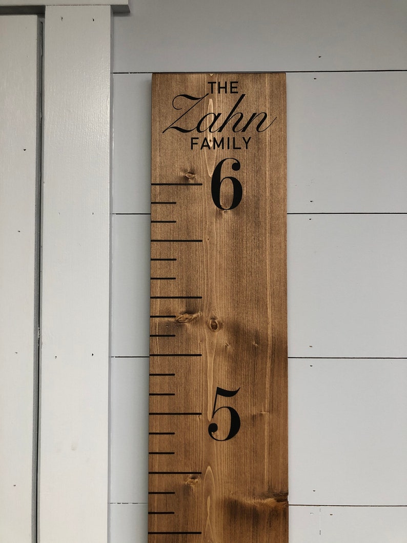 May include: A wooden growth chart with black markings and numbers. The chart is stained brown and has the text "The Zahn Family" at the top.