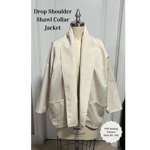 Könnte beinhalten: Eine beige Jacke mit fallenden Schultern, Schalkragen und Taschen. PDF-Schnittmuster. Größen XS - XXL.