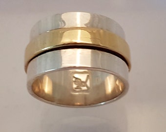 Handcrafted Solid Silver Ring with 3 micron 18 karat outer ring. uter ring rotates seperately from inner larger ring gold-plated center