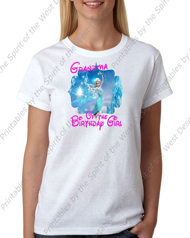 Peut inclure: T-shirt blanc avec un motif d'Elsa de La Reine des Neiges, et le texte "Grand-m&egrave;re de la fille d'anniversaire" en rose. Le motif comprend une sc&egrave;ne hivernale bleue et blanche. Le t-shirt est &agrave; col rond et &agrave; manches courtes.
