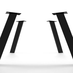 May include: Four black metal table legs with a slanted design. The legs are arranged in a symmetrical pattern, with two legs on each side of the image.